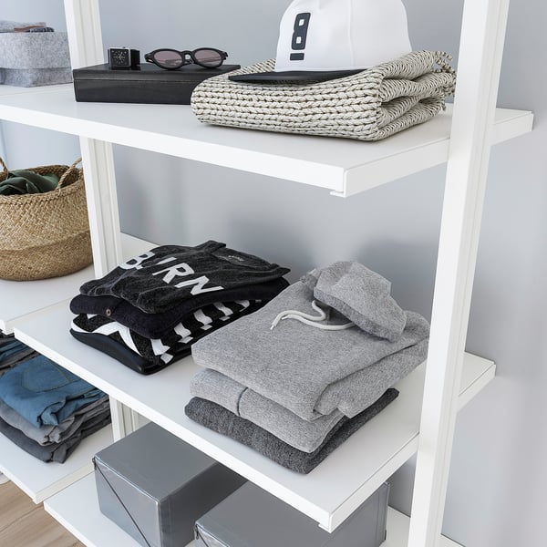 Shelf organiser with neatly folded clothes and accessories. Adjustable height and storage versatility.