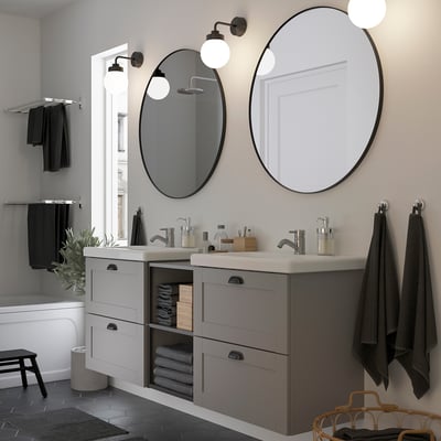 Modern grey vanity, double sinks, black accents, mirrors, storage, window.