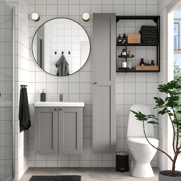 Modern bathroom: white/gray, round mirror, slim vanity, tall cabinet, black accents, minimalist, well-lit.