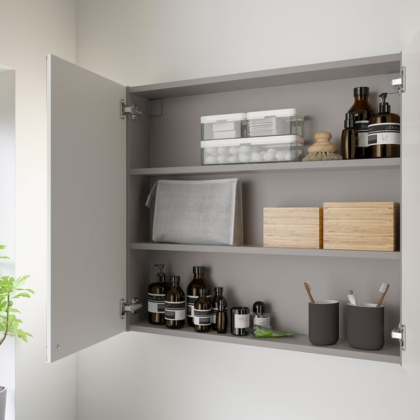 Open wall cabinet with mirrored doors, displaying toiletries on shelves, offering easy access and storage.