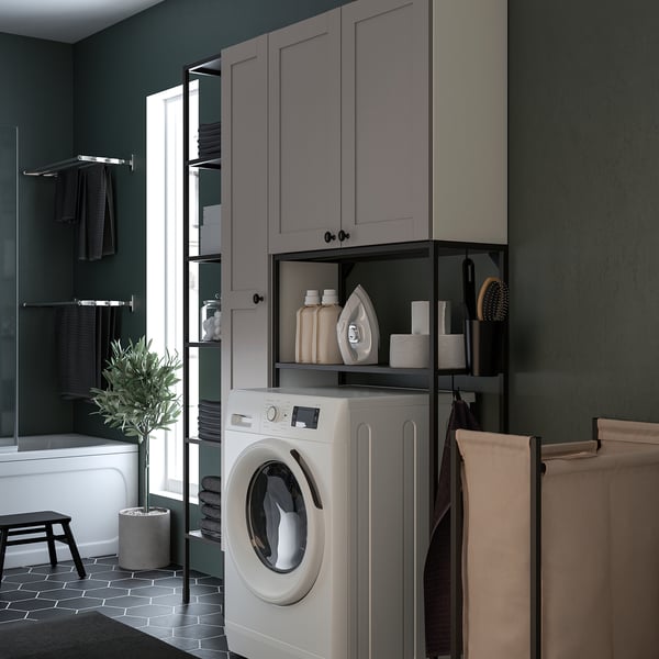 Grey ENHET laundry unit with washer-dryer, open & closed storage, shelves, and mobile laundry bag.