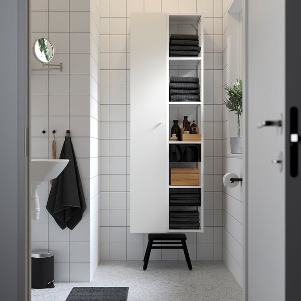 Modern bathroom with tall ENHET cabinet, shelves, stool, grey walls, door, and sink.