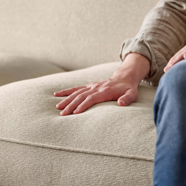 Hand on ESSEBODA sofa, beige, soft fabric, deep seat, high backrest.