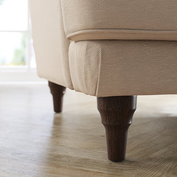 Modern sofa with beige upholstery, dark wood legs.