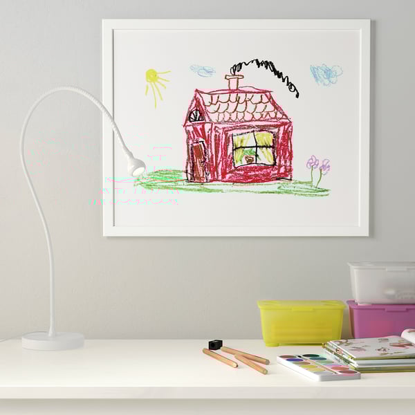 Framed childs drawing in FISKBO with colours and art supplies below, showcasing creative space.