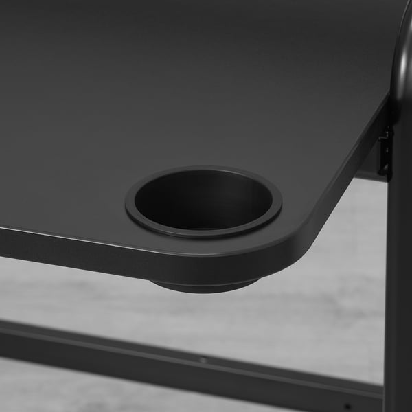 Black desk with circular cup holder, smooth finish, sleek design.