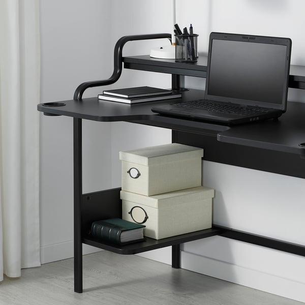 Modern black desk with laptop and storage. Include cable management and contoured table top for wrist support.