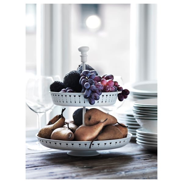 White GARNERA 2-tier serving stand with fruit on rustic wooden table, stylish and practical.