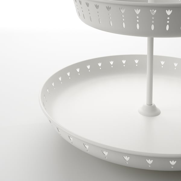 White, two-tiered metal serving stand with intricate floral cutouts. Sturdy, stylish design for serving food.