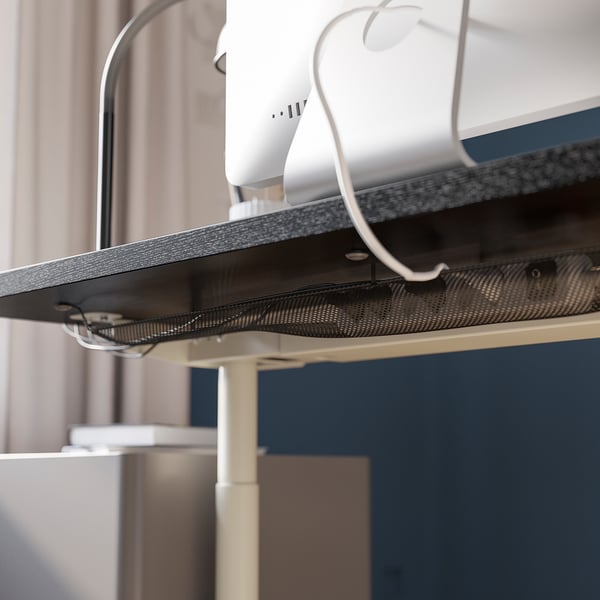 Under desk cable management net shown, keeping cords tidy. Sturdy tabletop with adjustable legs from 62 to 76 cm.
