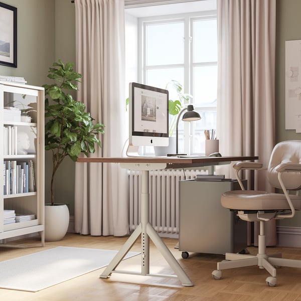 Modern home office with IDÅSEN desk, computer, lamp, and plant.