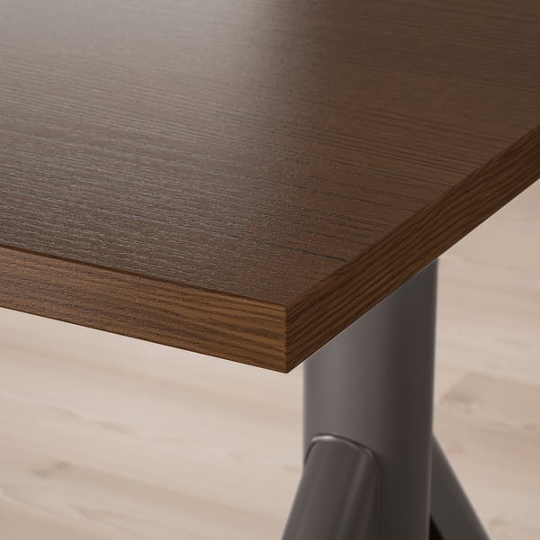 Dark wooden desk with smooth, polished surface and sturdy metal legs visible at the corner.