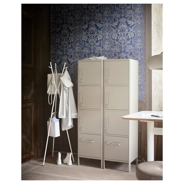 Beige IDÅSEN storage cabinet with silver handles against blue wall.