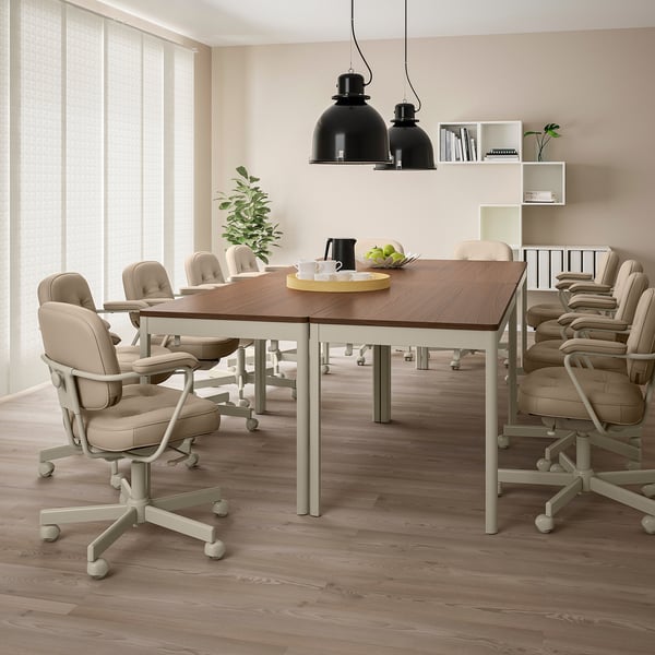IDÅSEN conference table with beige chairs, pendant lights, and bookshelf in a bright room.