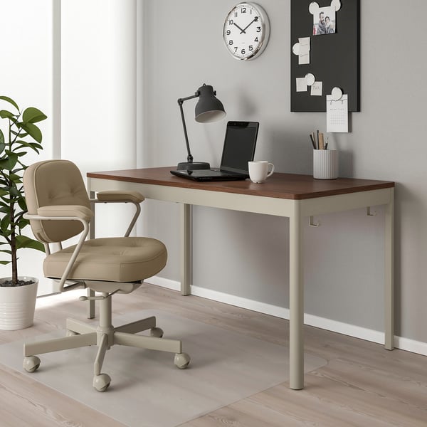 Modern IDÅSEN desk with wooden top, white legs, laptop, chair, and greenery.