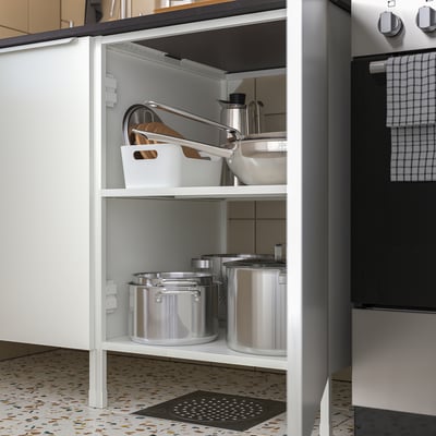 Open kitchen cabinet with pots, pans, and storage containers neatly organised on shelves.