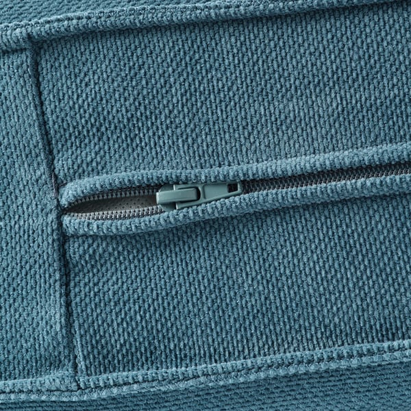 Close-up of soft, textured blue blanket with zip detail. Highlights cosy, durable material.