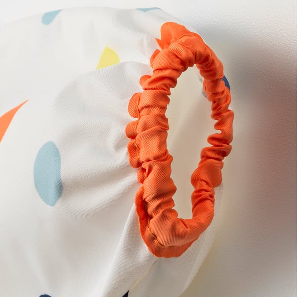 White bib with colourful patches; bright orange headband, soft, adjustable.