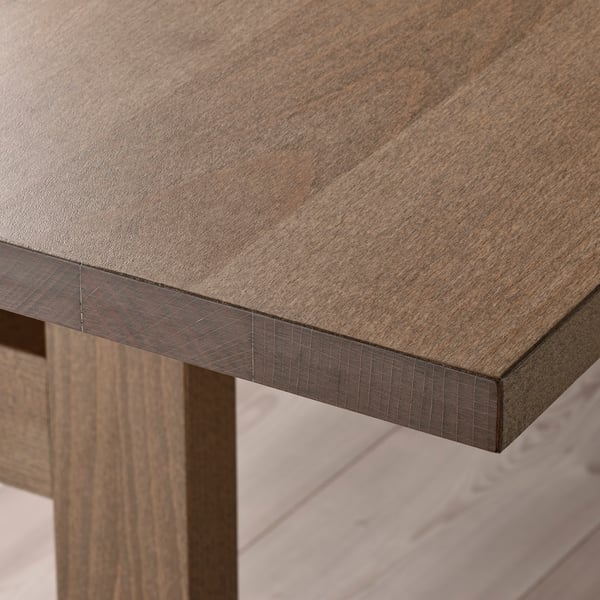 Wooden table edge, smooth finish, even grain texture.