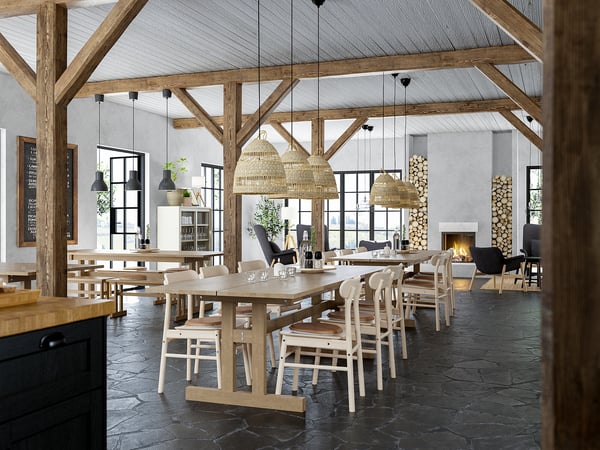 Large, rustic dining space with wooden tables, chairs, and pendant lights. Spacious with stone floors and a cosy fireplace.