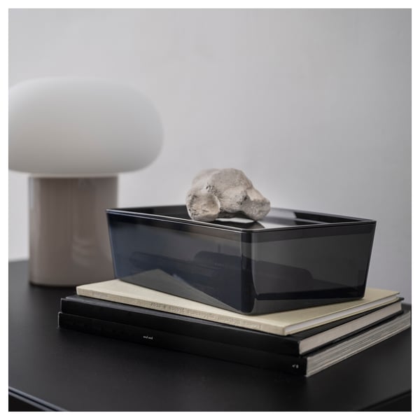 KUGGIS black box on books with a white lamp, minimalist design.