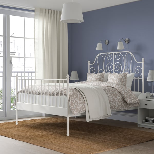 LEIRVIK bed with curves against blue wall. Large window left, nightstands both sides, spacious room.