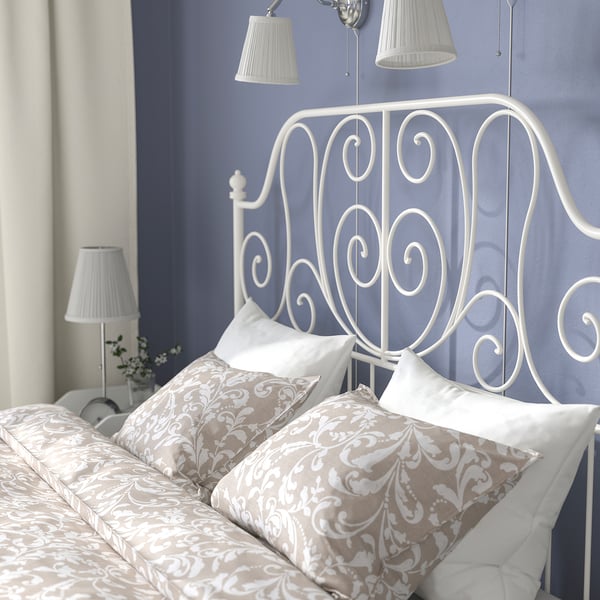 Elegant bedroom with LEIRVIK bed, white metal frame, decorative headboard, matching lamps, floral bedding.