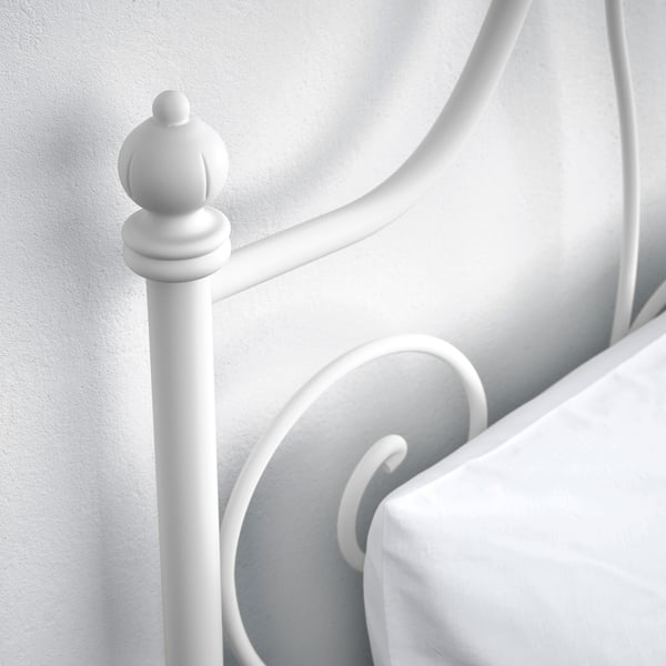 White metal bed frame with elegant, curved design. Headboard decorative finials; sturdy and stylish.