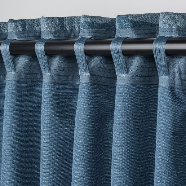Close-up of blue block-out curtains with looped rod pockets, showcasing their light-blocking and hanging functionality.