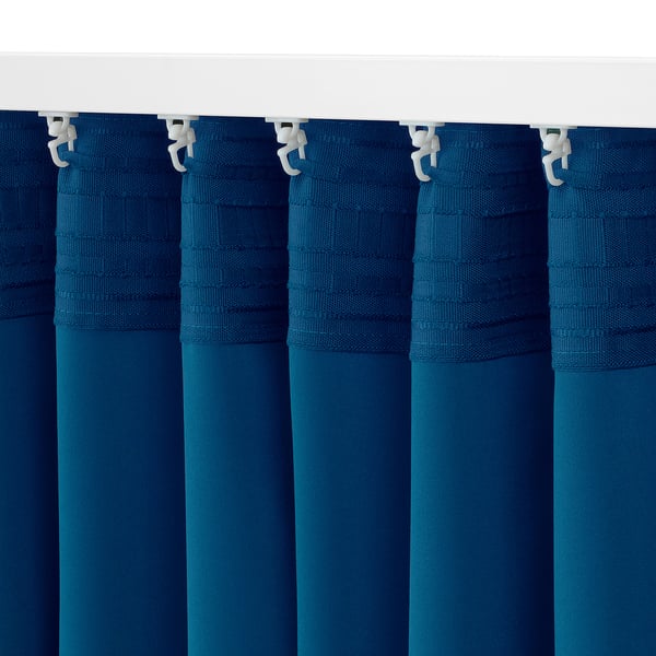 Dark blue block-out curtains with hooks hang neatly, ensuring privacy and light control.