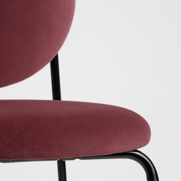 Close-up: red velvet office chair seat. Modern, plush, supported on metal frame.