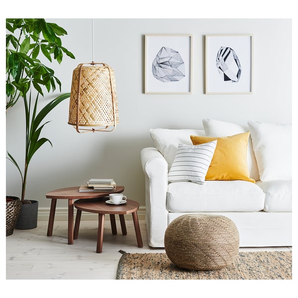 Modern living room with white sofa, woven pendant lamp, wooden tables, beanie chair, plant, and abstract wall art.