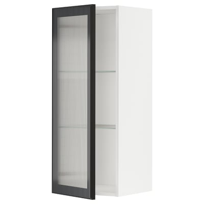 Displays a white METOD kitchen cabinet with a black hejsta glass door, featuring a reeded glass design and a sleek metal frame.