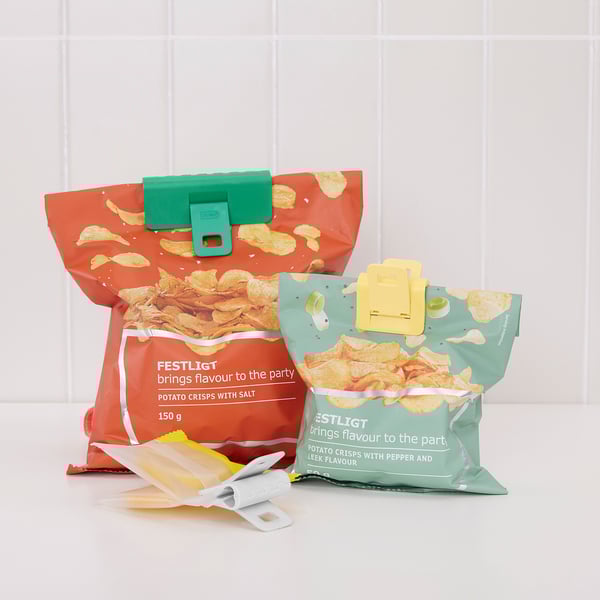 Three chip bags, sealed with green, yellow, and white clips, on white surface.