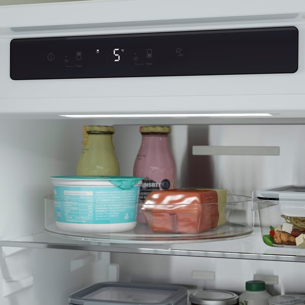 Open refrigerator with led display showing temperature and food items stored inside.