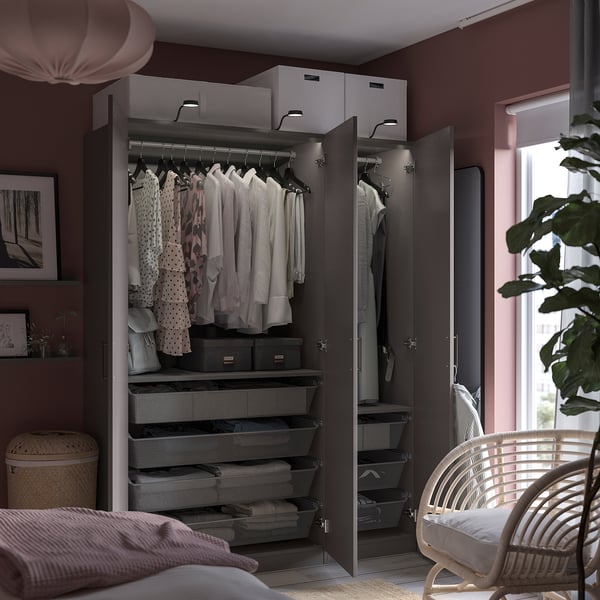 Modern black PAX wardrobe with patterned chairs, white clothes, and grey storage bins.