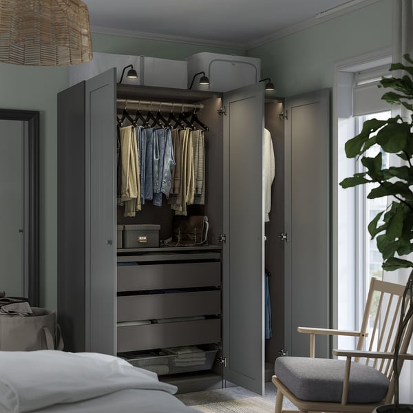 A modern grey wardrobe with open doors revealing clothes, drawers, and shelves showcasing its practical and organised interior.