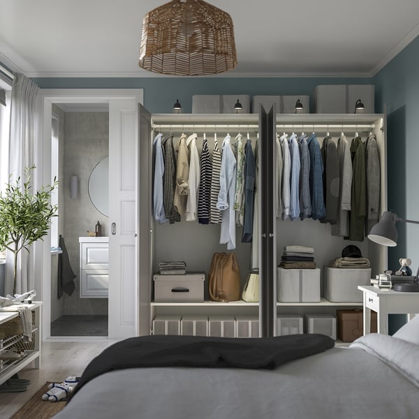 Modern bedroom with open wardrobe, neatly organised teal room.