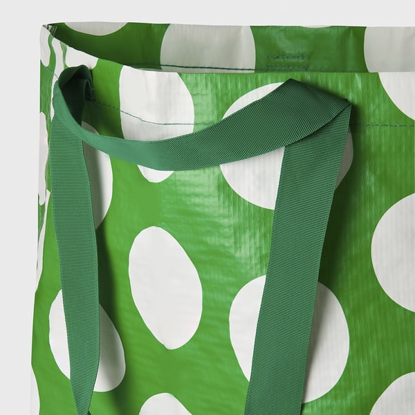 Green tote bag with white polka dots, featuring strong, adjustable straps for comfortable carrying.