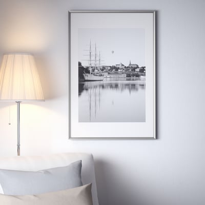 Framed b&w waterfront photo above couch.