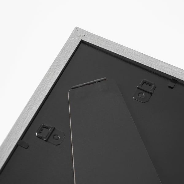 Black metal picture frame with two hanging clips and front protection, standing upright.