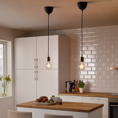 Modern kitchen with SKAFTET lights over fruit-filled island.