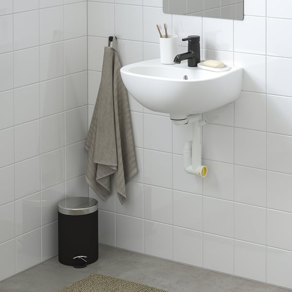 Wall-mounted SKATSJÖN basin, soft shapes, deep, grey towel, black bin.