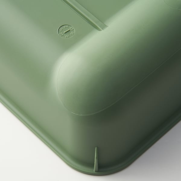 Green kitchen strainer; smooth, matte surface; compact design with anti-slip feet.