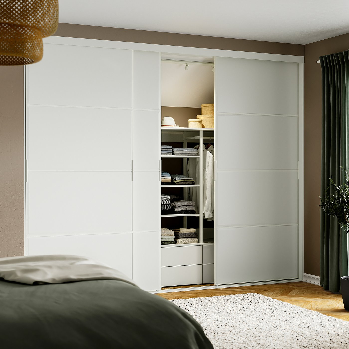 Modern bedroom with large white sliding wardrobe, containing neatly organised clothes and shelves, adjacent to a bed with green blanket.