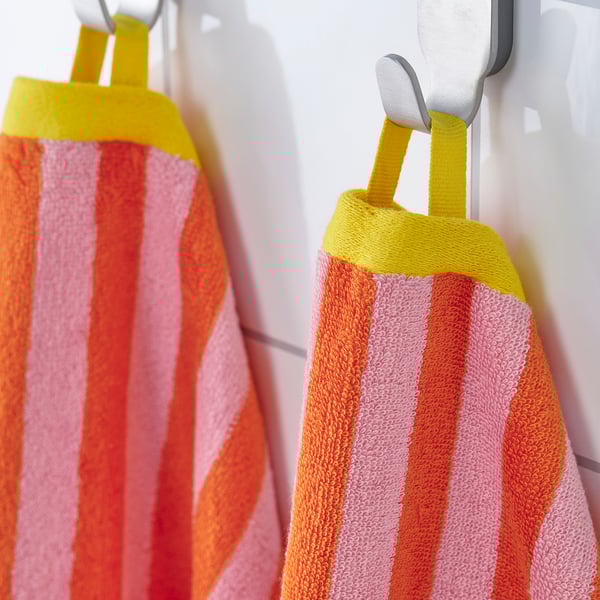 Two striped towels hang from hooks, showcasing their absorbent, colourful stripes.