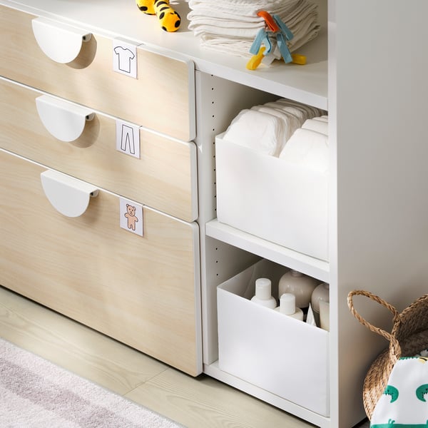 Baby changing table with white organisers, drawers labelled with toys, and baby essentials.