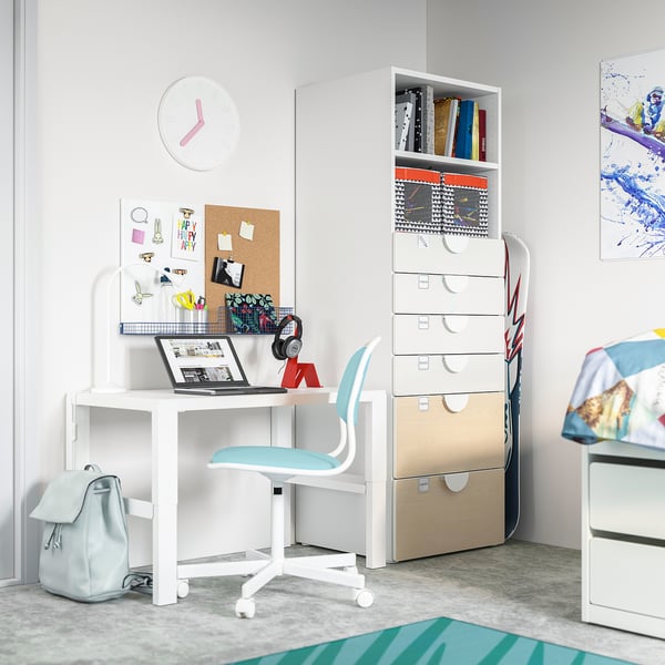 Teenage study space with white SMÅSTAD desk, light blue chair, storage unit, wall clock, and backpack. Includes laptop, headphones, and supplies.