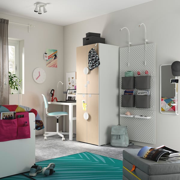 Bedroom with SMÅSTAD wardrobe, desk, & chair. Light wood, plants, grey rug, green mat, blue backpack, & clock.