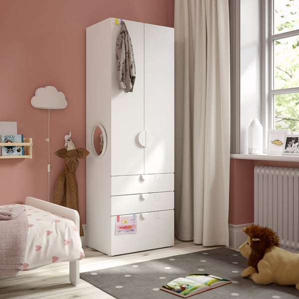 Kids room with SMÅSTAD wardrobe, heart bedding, lion toy, and window view.